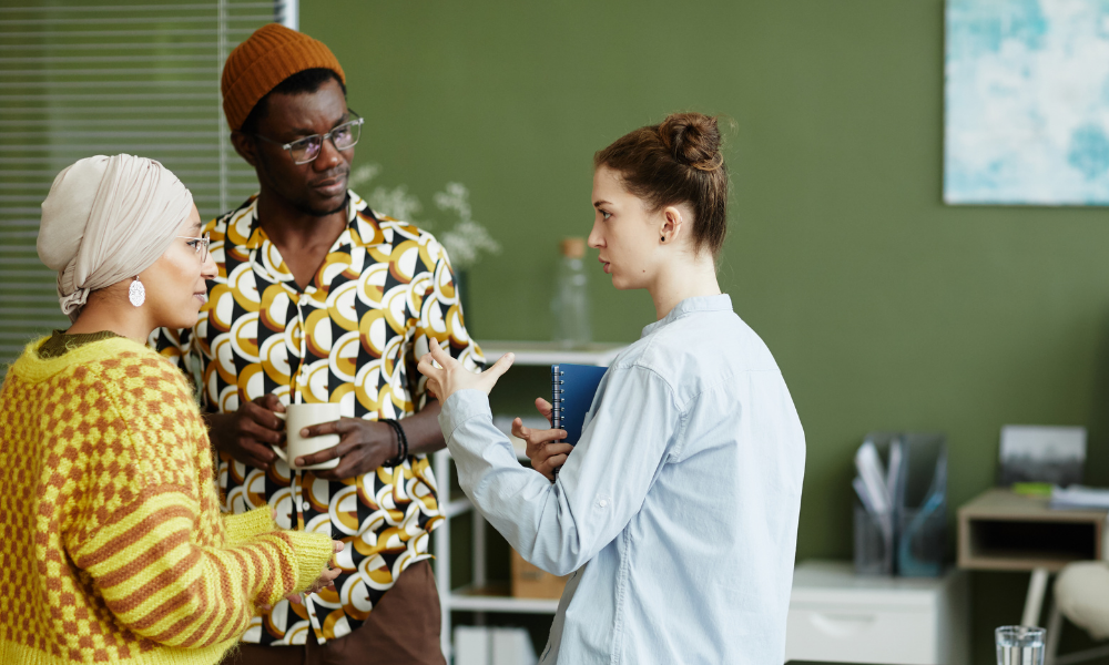 Three employees having an informal chat in the office on a coffee break